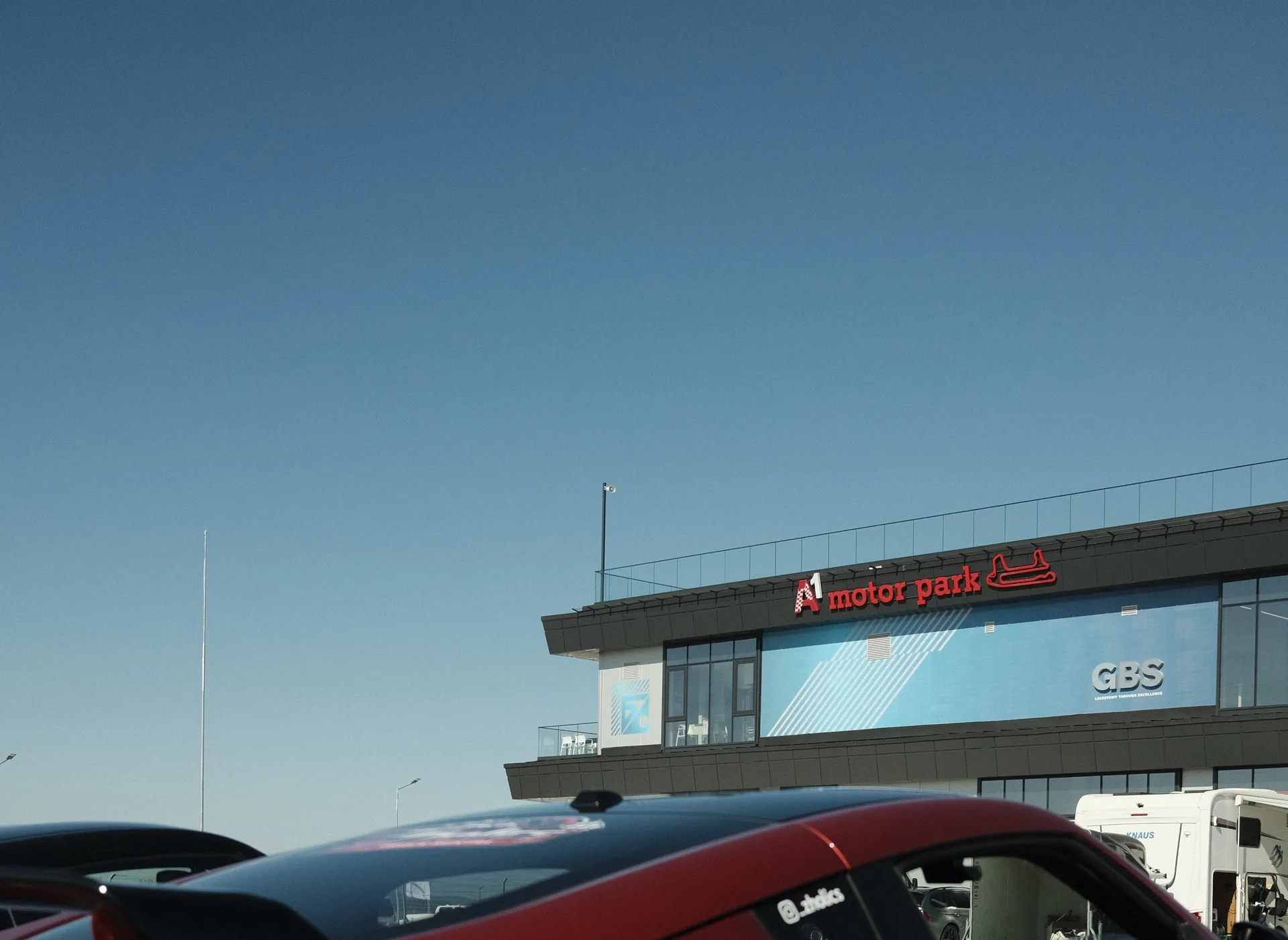 The A1 Motor Park pit building and sign, with a Zholics 370Z parked in front