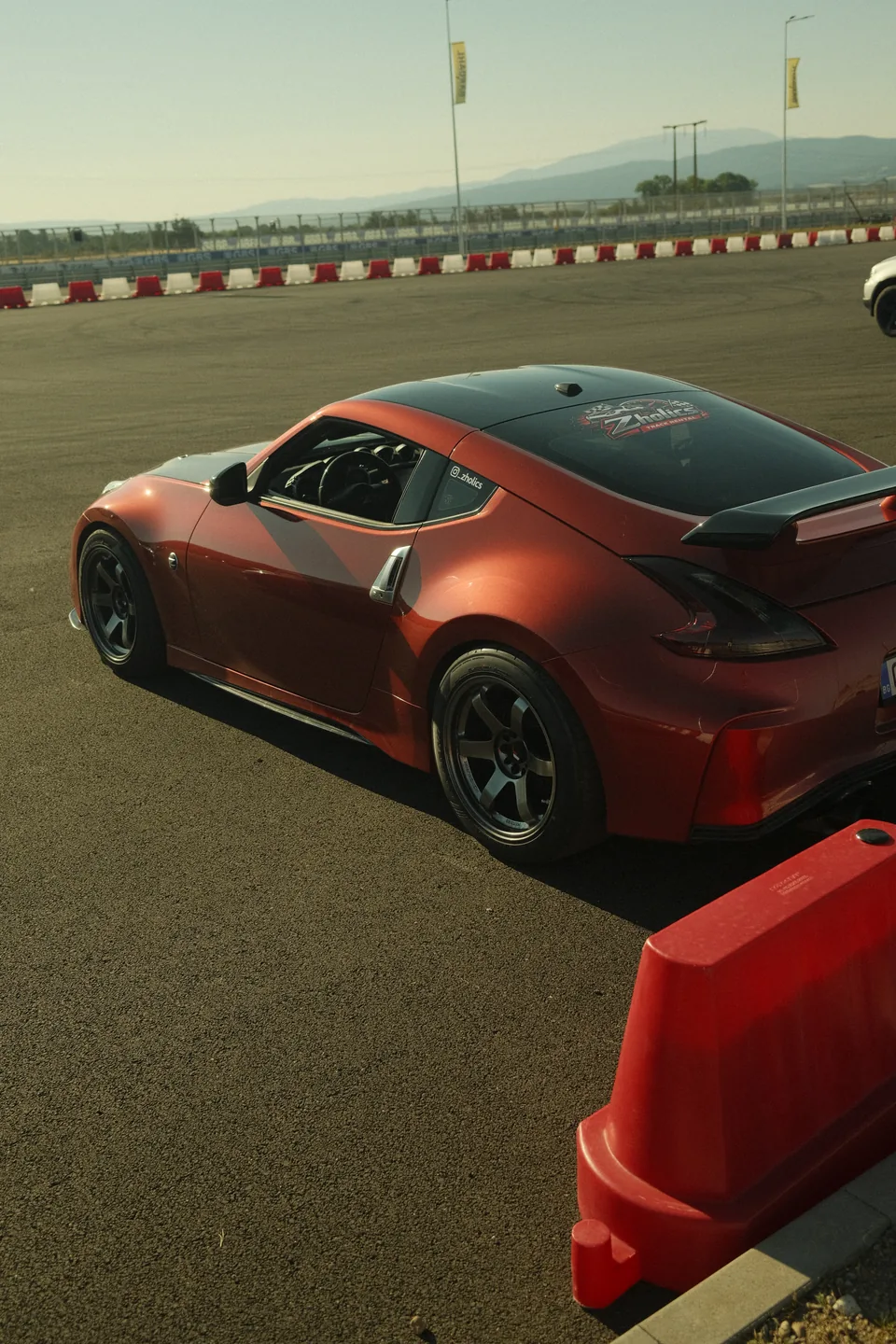 Zholics 370Z AAM Twin Turbo in red, rear three-quarter view showing its rear wing